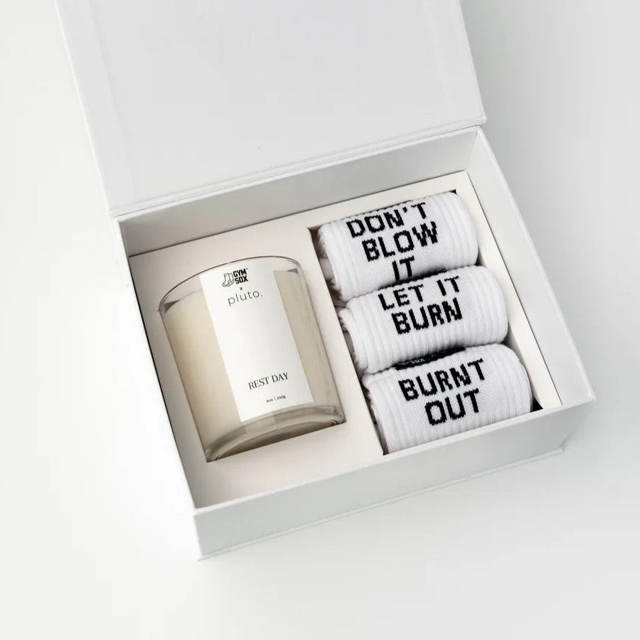 Candle and socks set in a white box with humorous text on the socks.