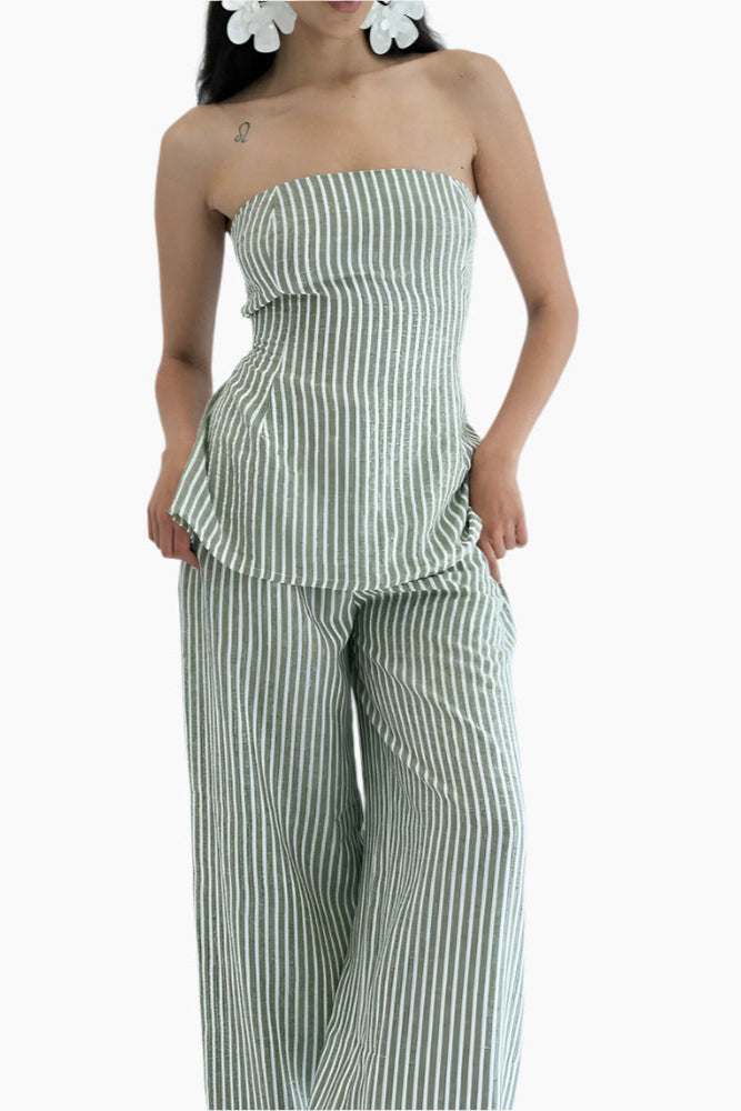 Woman wearing a green and white striped strapless top and wide-leg pants