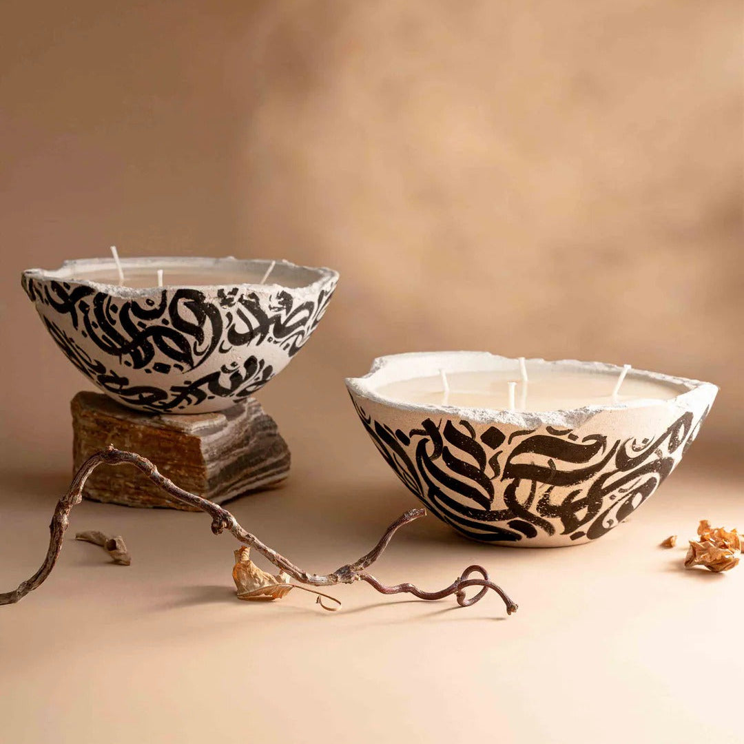 Two decorative bowls with black patterns on a beige background