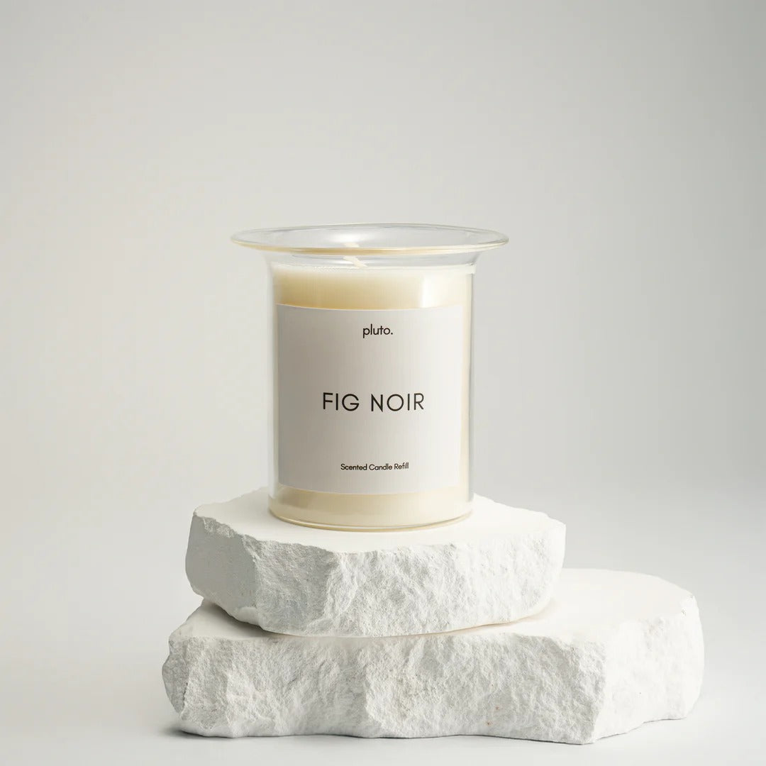 Candle labeled 'Fig Noir' by 'pluto.' on a white background