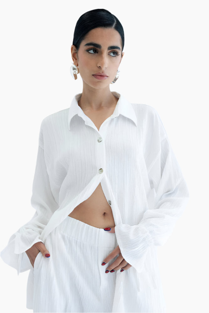 Woman wearing a white button-up shirt and white pants