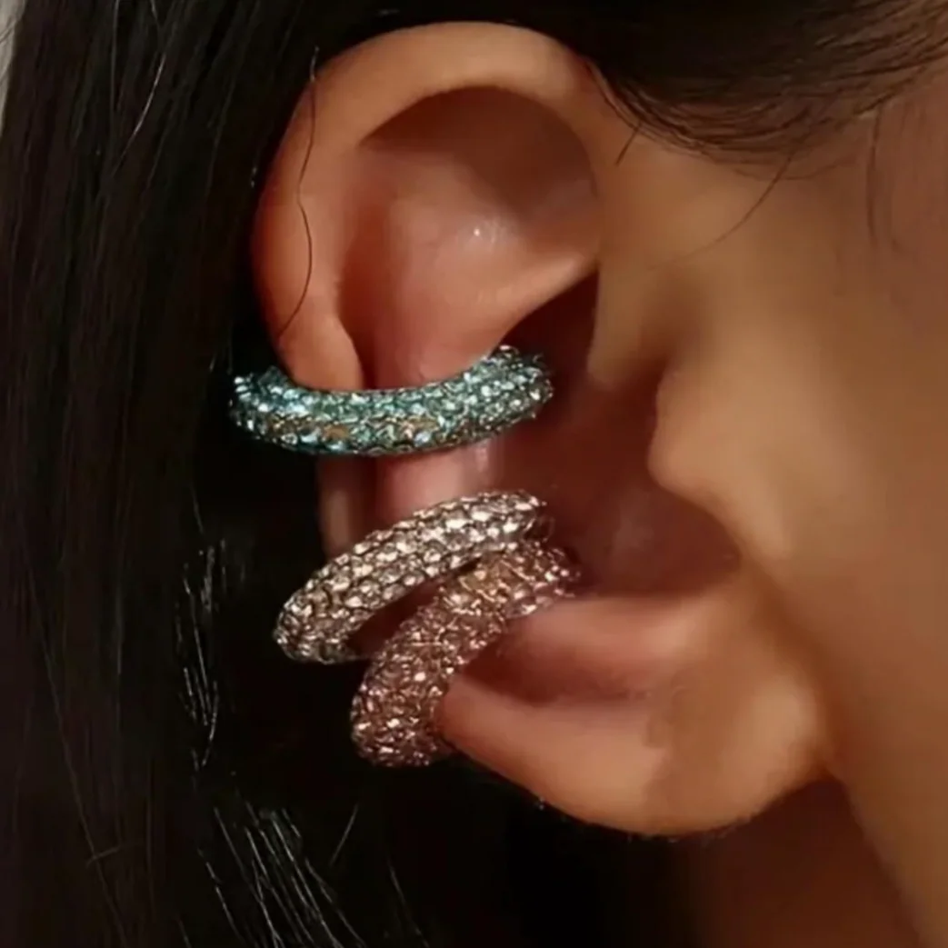 Close-up of an ear wearing two sparkling earrings.