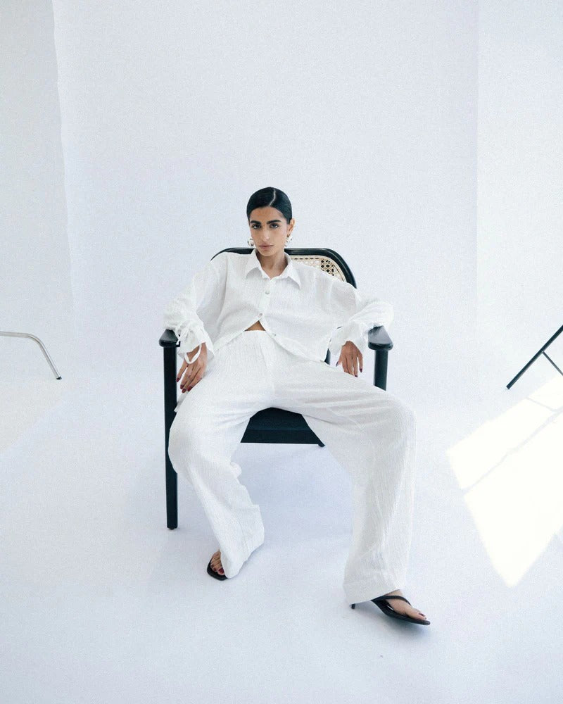 Person wearing a white outfit sitting on a chair
