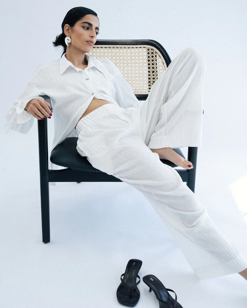 Person wearing a white outfit sitting on a chair
