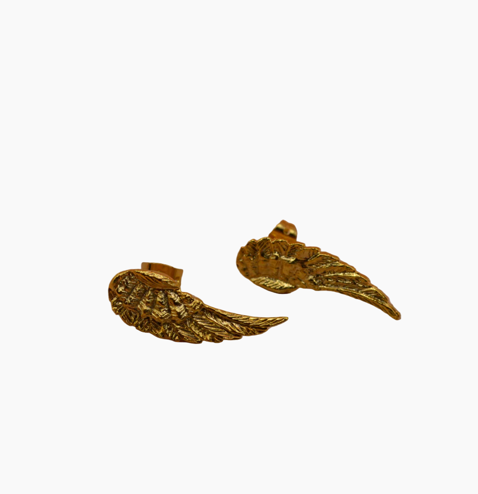 Pair of gold wing-shaped earrings on a white background
