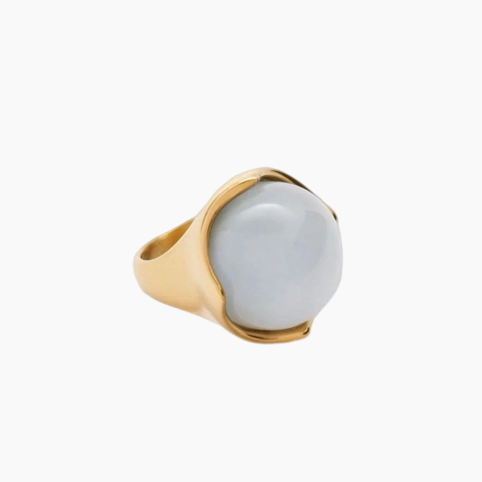 Gold ring with a large white stone on a white background
