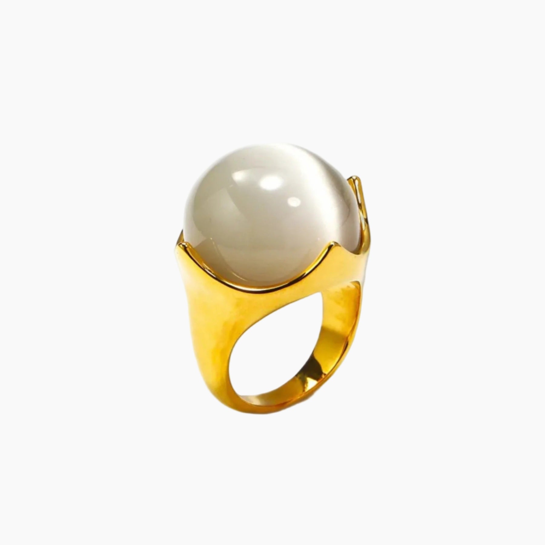 Gold ring with a large white pearl on a white background