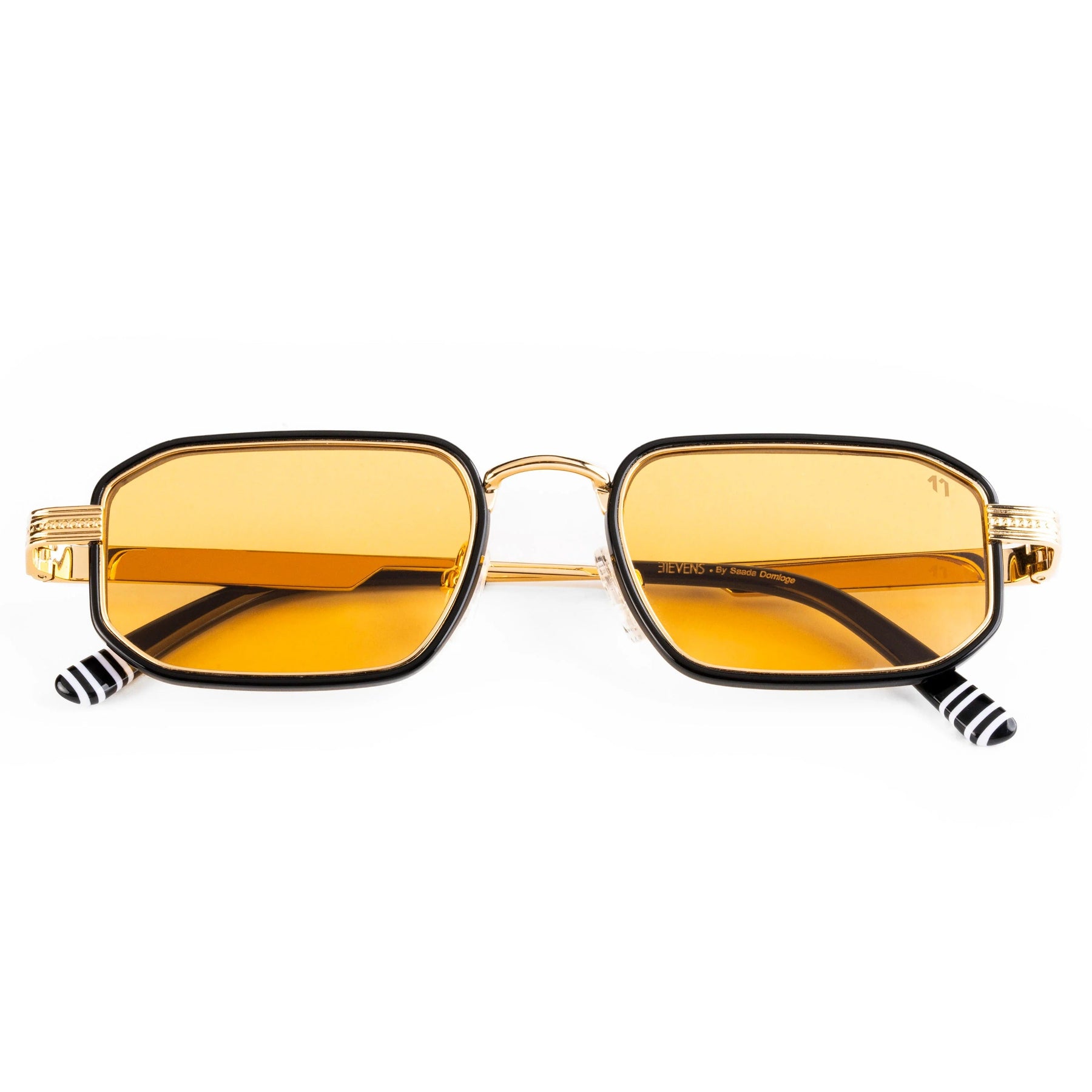 Sunglasses with gold frame and yellow lenses on a white background