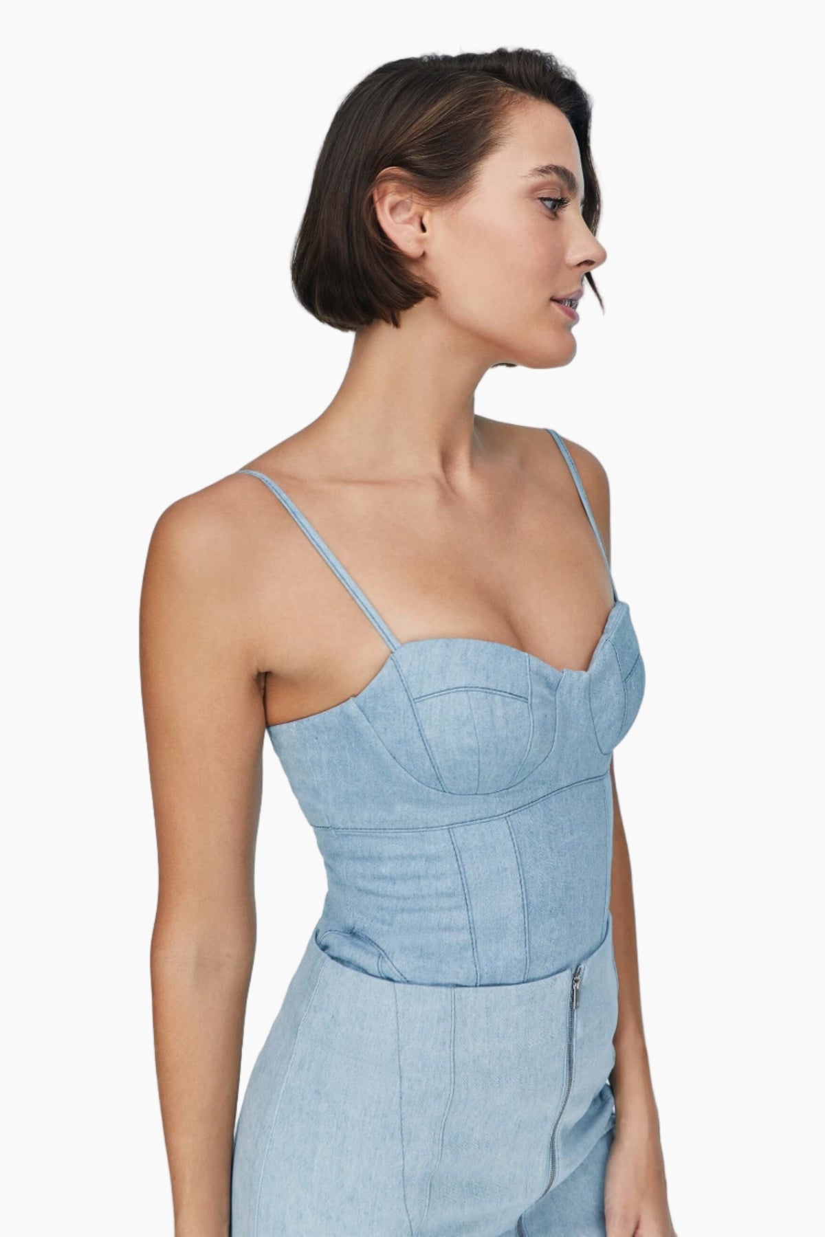 Woman wearing a nesta blue denim, this top feature sultry bustier neckline and chic corset shape