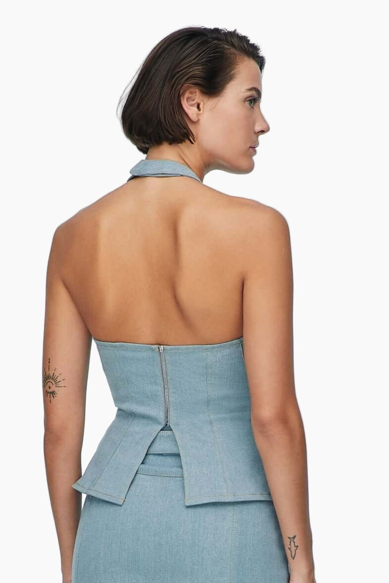 Woman wearing a light blue halter-neck and corset-shaped with a matching skirt