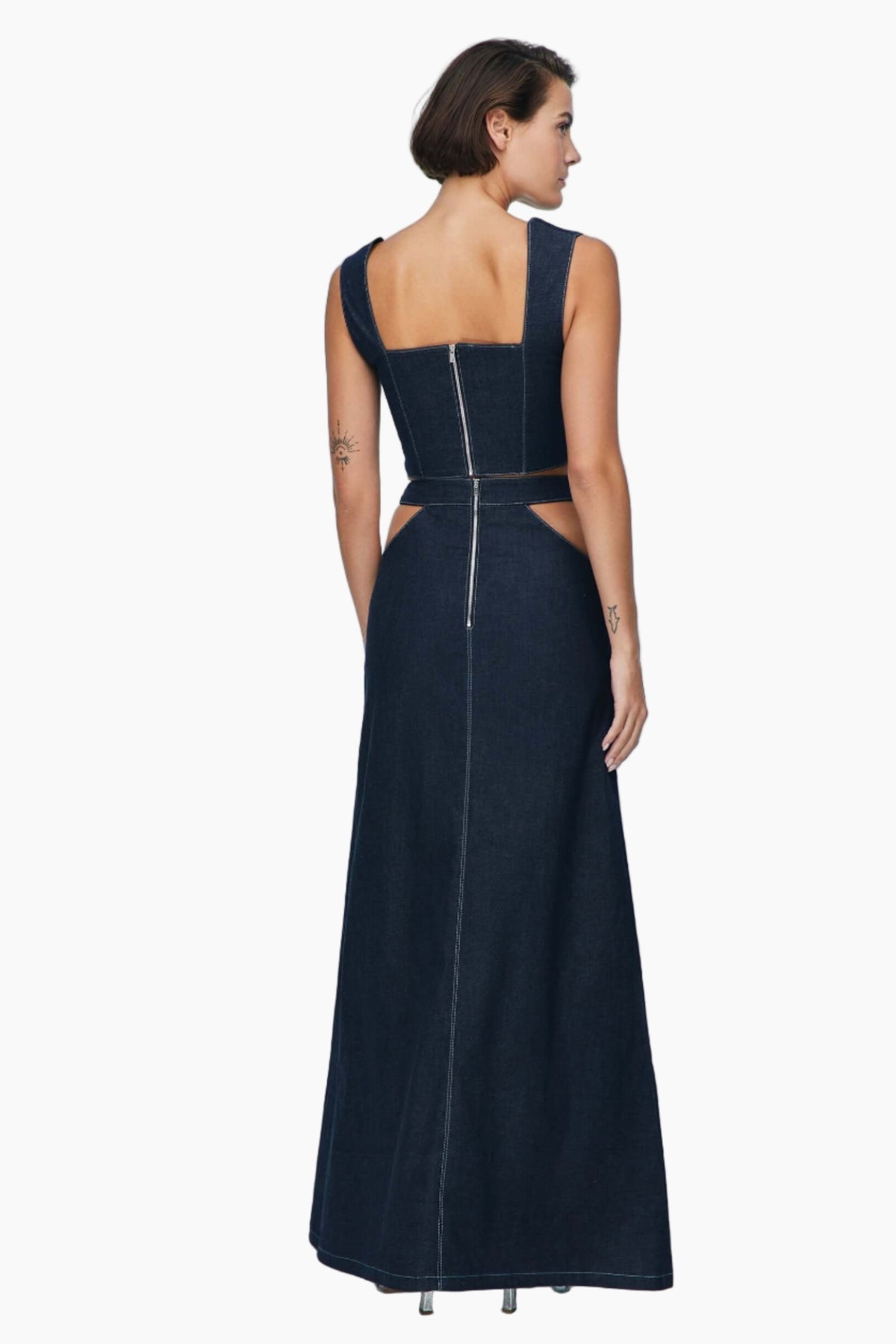 women wearing a sleeveless denim crop top with a matching denim maxi skirt, Lycra denim, features cut outs under the belt and a side slit.