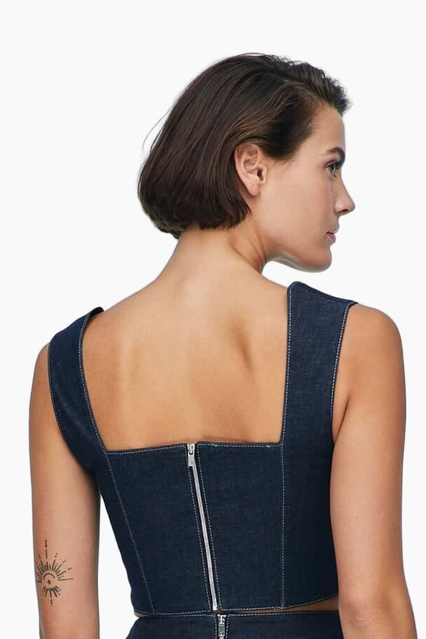 Woman wearing a blue denim dress top with a zipper back