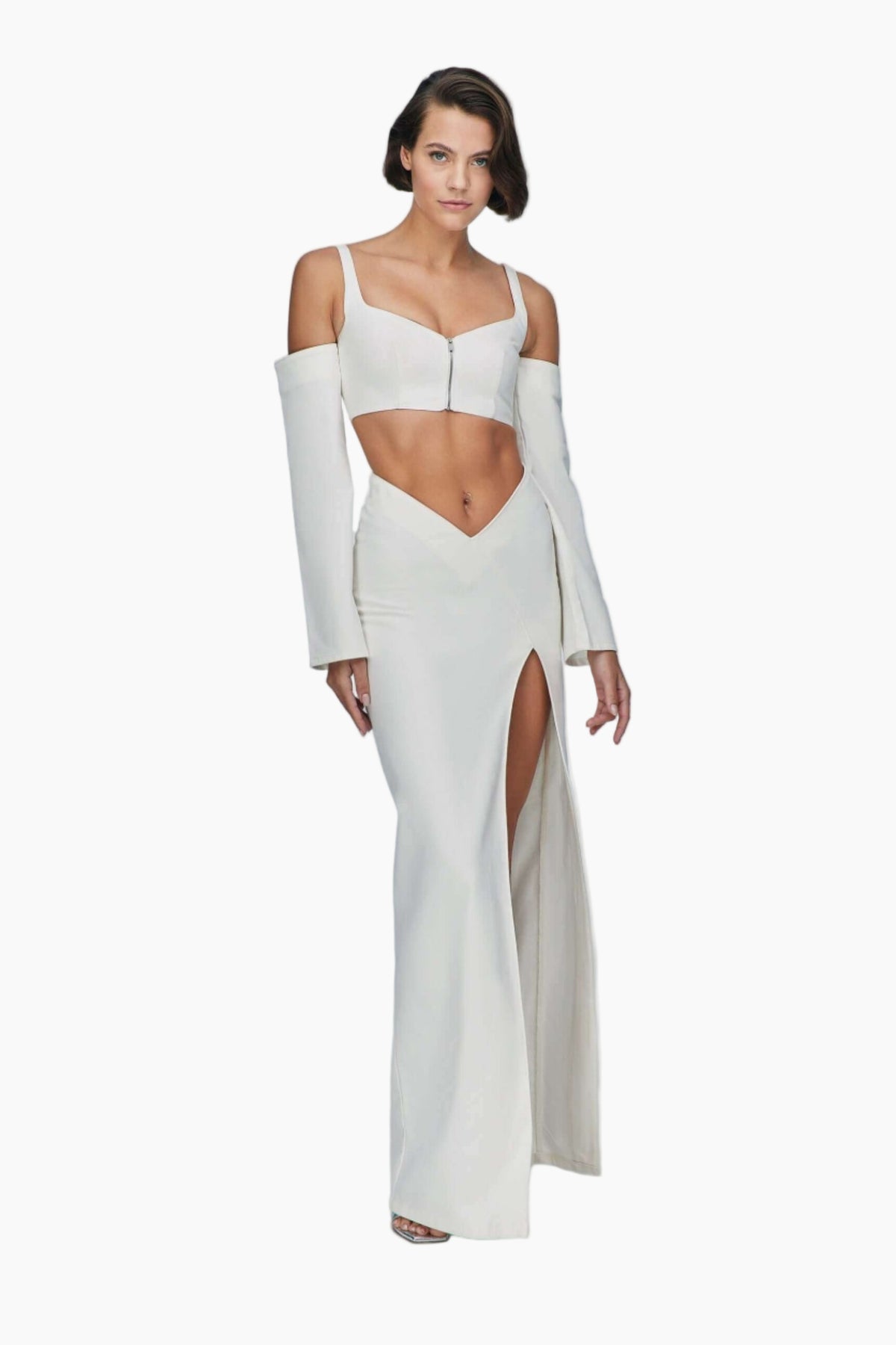 Woman wearing a white top and maxi skirt features an asymmetric waist and a stylish side slit.