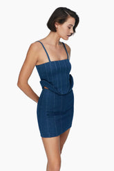 women wearing a mini denim skirt, Secured with a metallic zipper. Vertical patterns with a matching top.