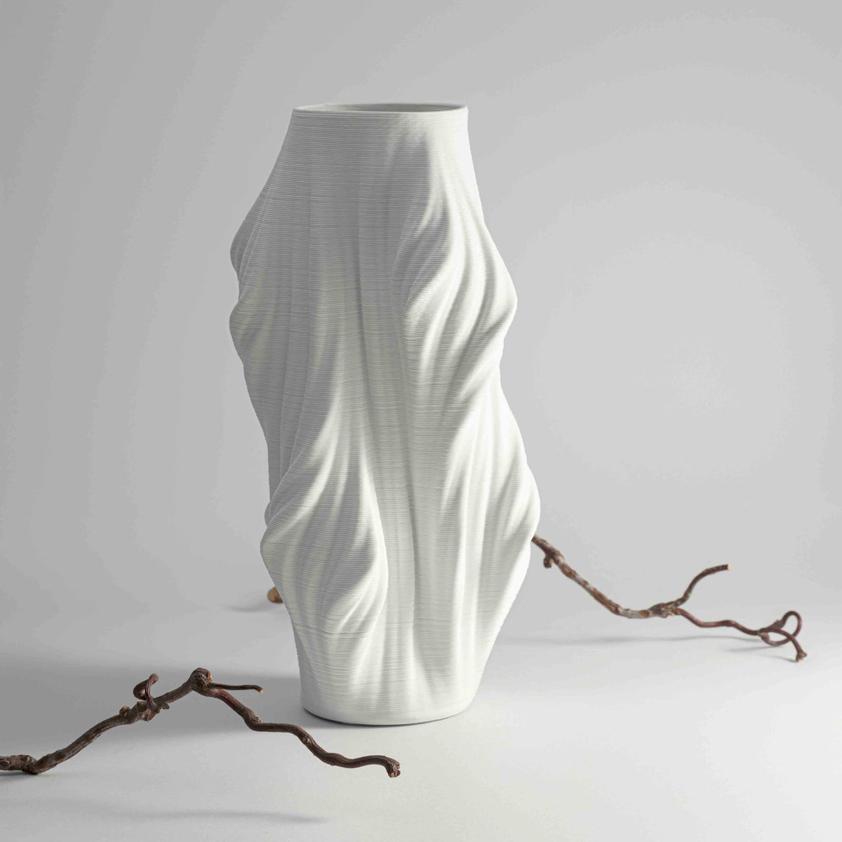 vase features a sculptural, organic design with fluid, wave-like folds