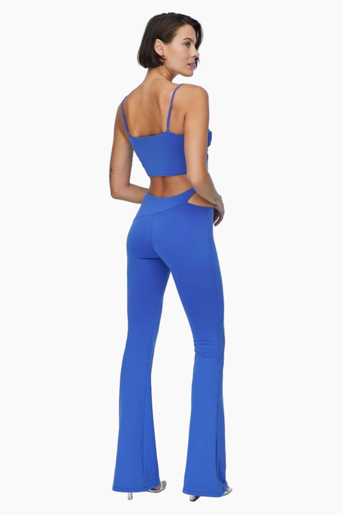 Woman wearing a blue jumpsuit Featuring asymmetric cut out details and chic straps.