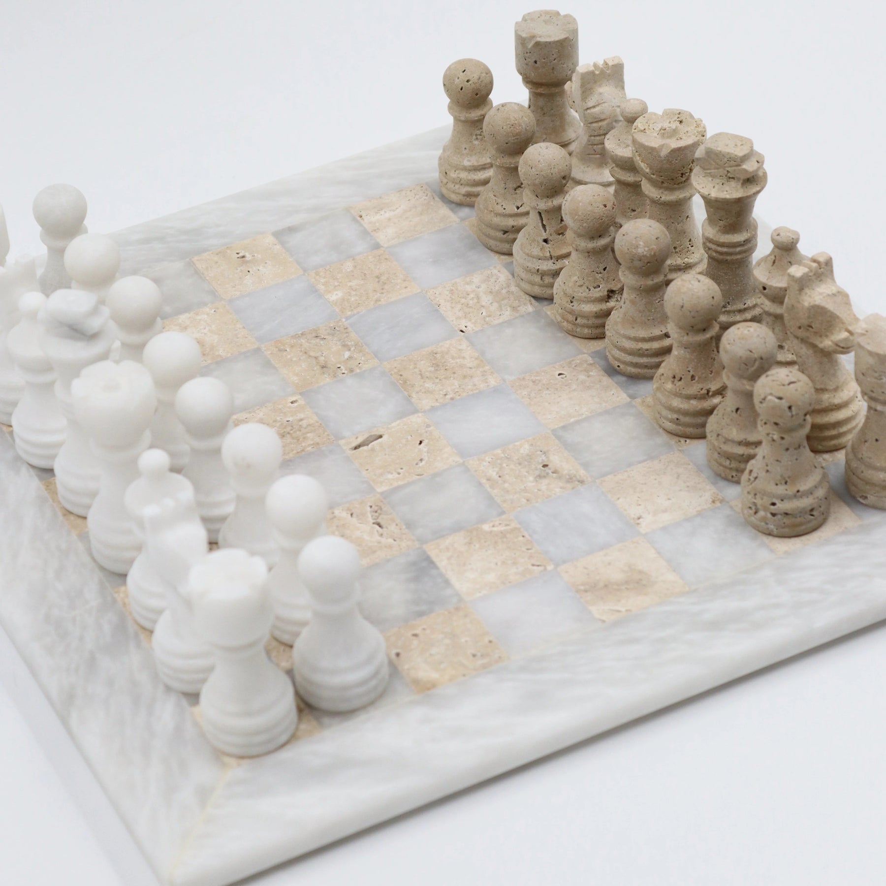 Marble chessboard with white and beige pieces on a white background