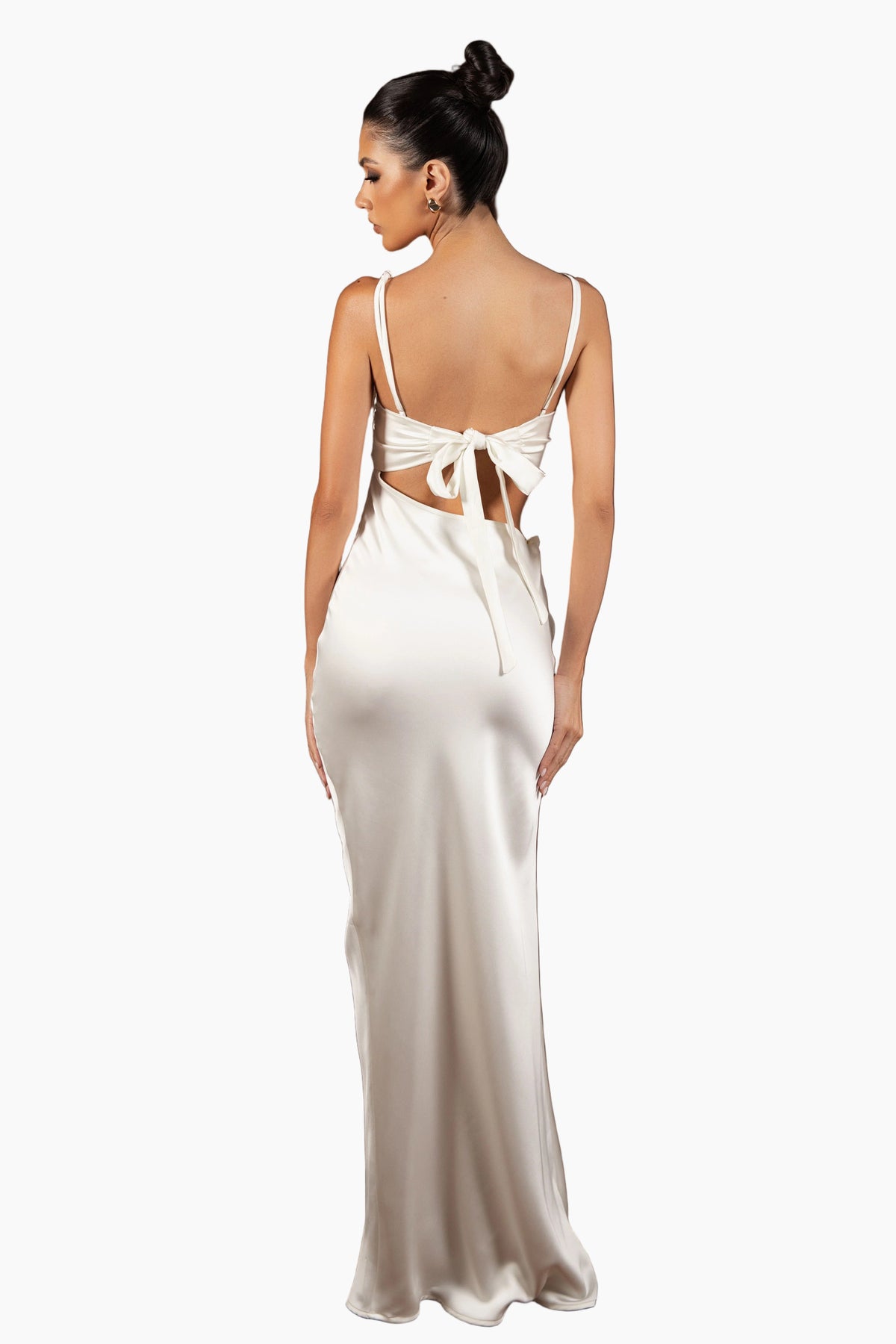 Woman wearing a white evening gown with cut-out design on a brown background