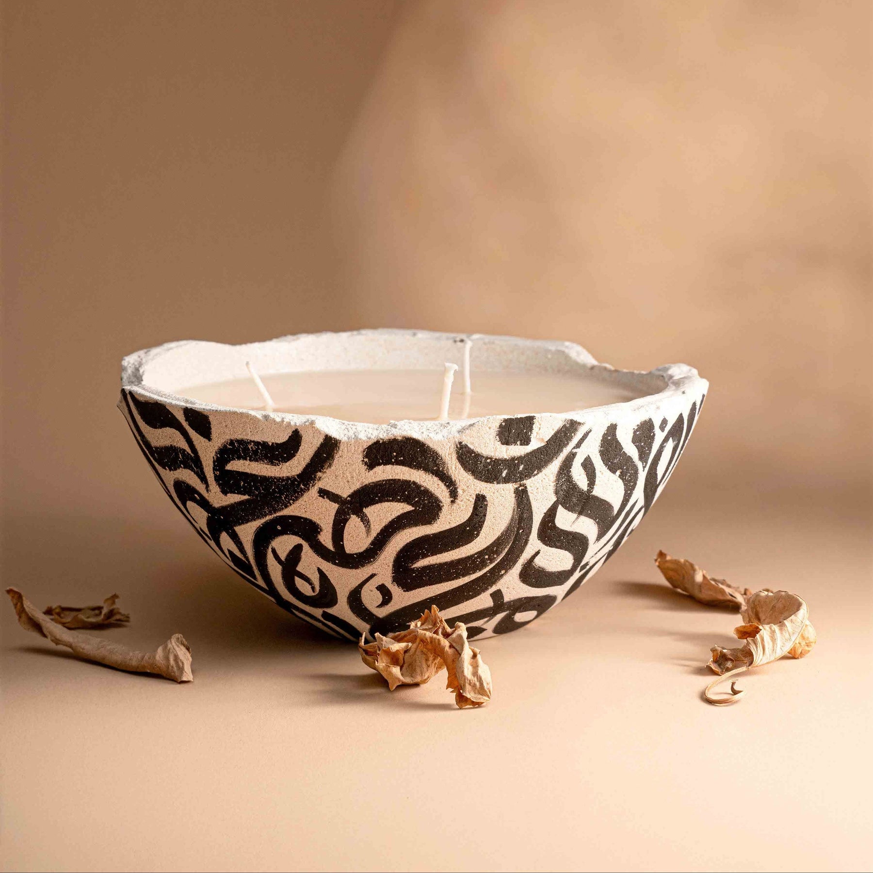 Ceramic bowl with black abstract patterns on a beige background