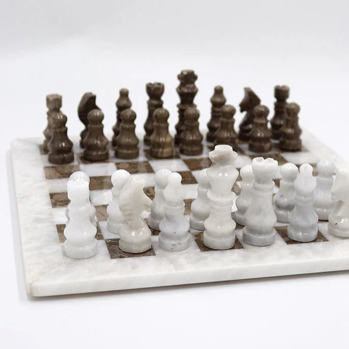 Marble chess set with white and brown pieces on a white background