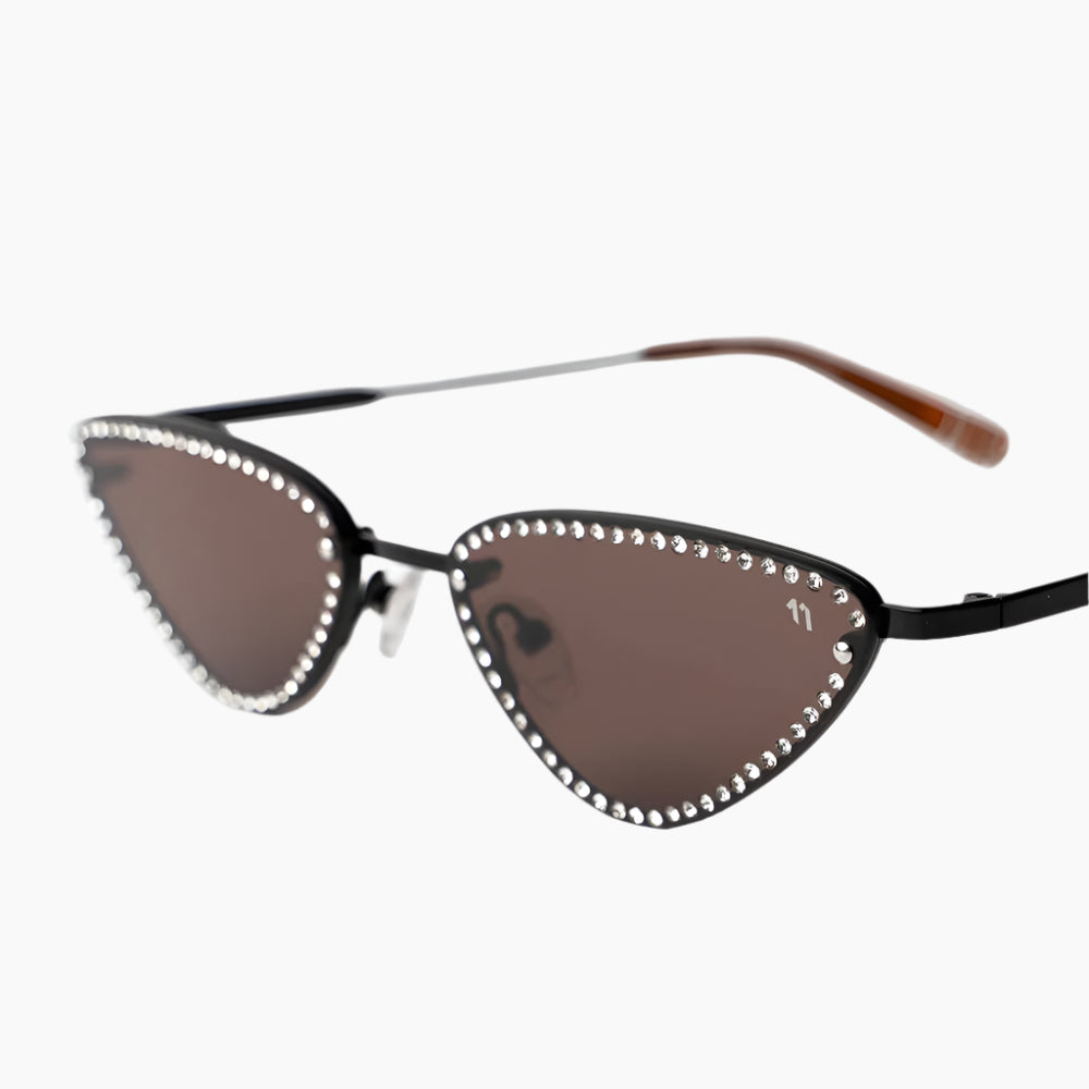 Cat-eye sunglasses with decorative embellishments on a white background