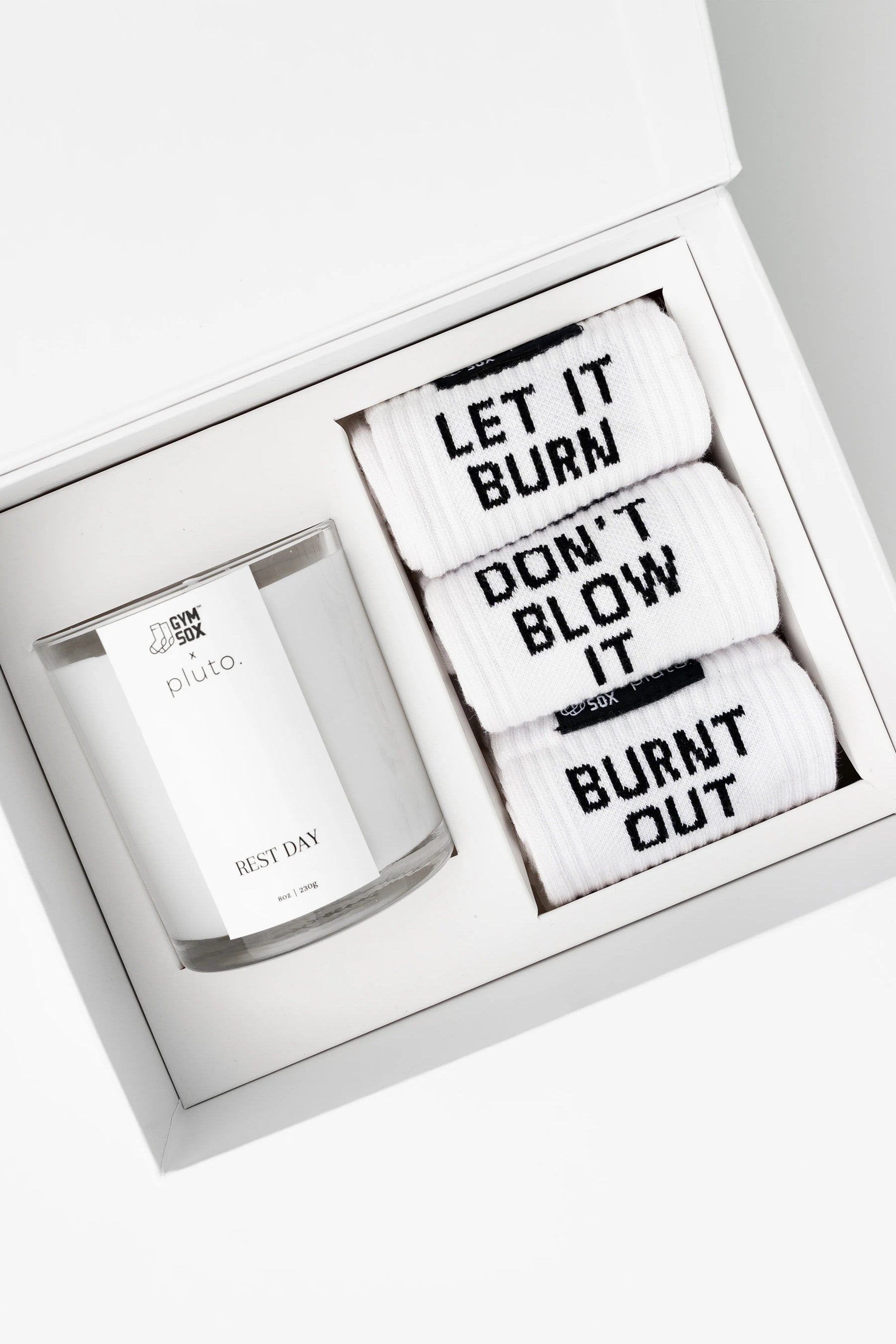 Set of candles with motivational phrases in a white box