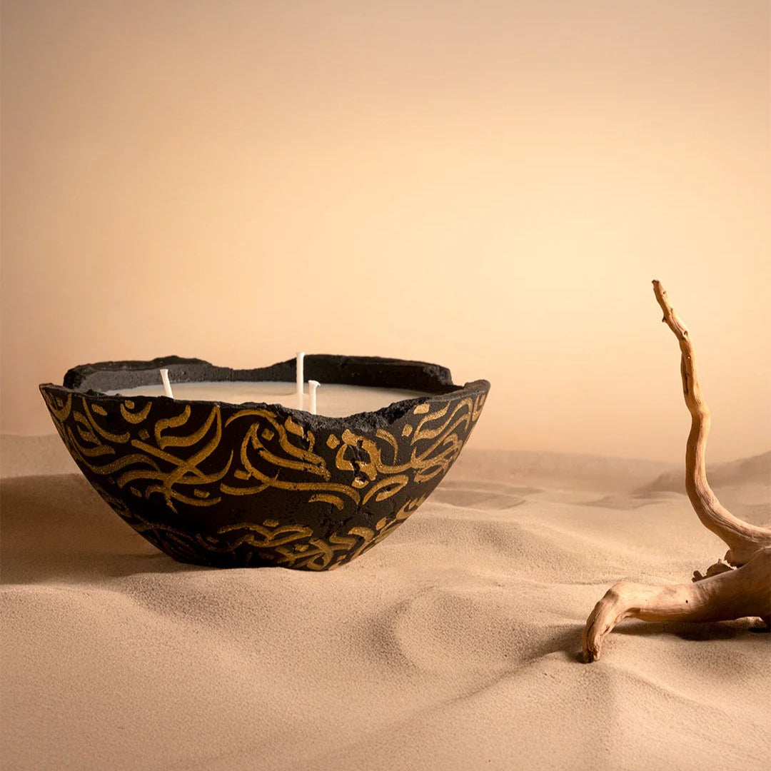 Decorative bowl with gold patterns on a sandy surface