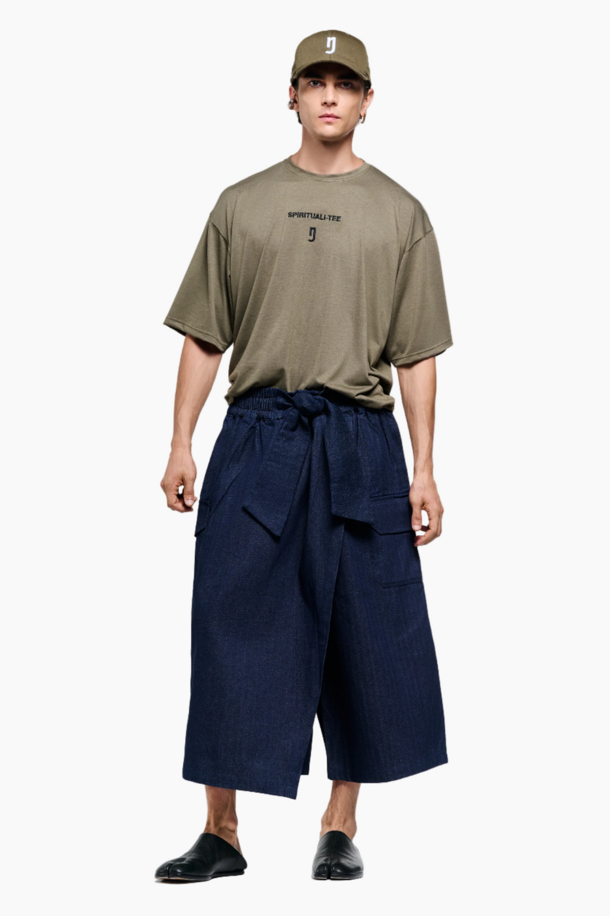 Person wearing a green t-shirt and navy pants on a white background