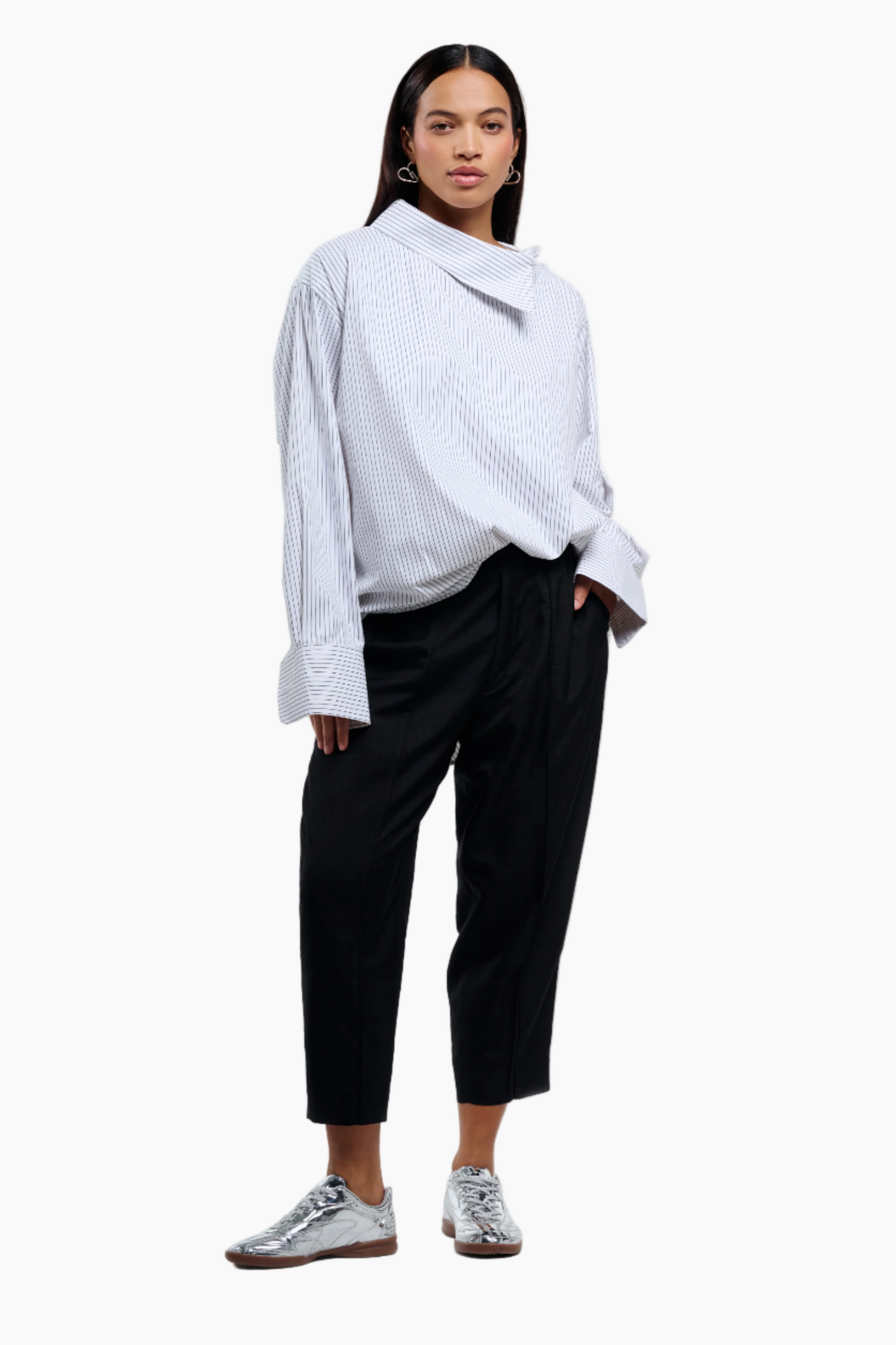 Person wearing a light blue shirt and black pants on a white background