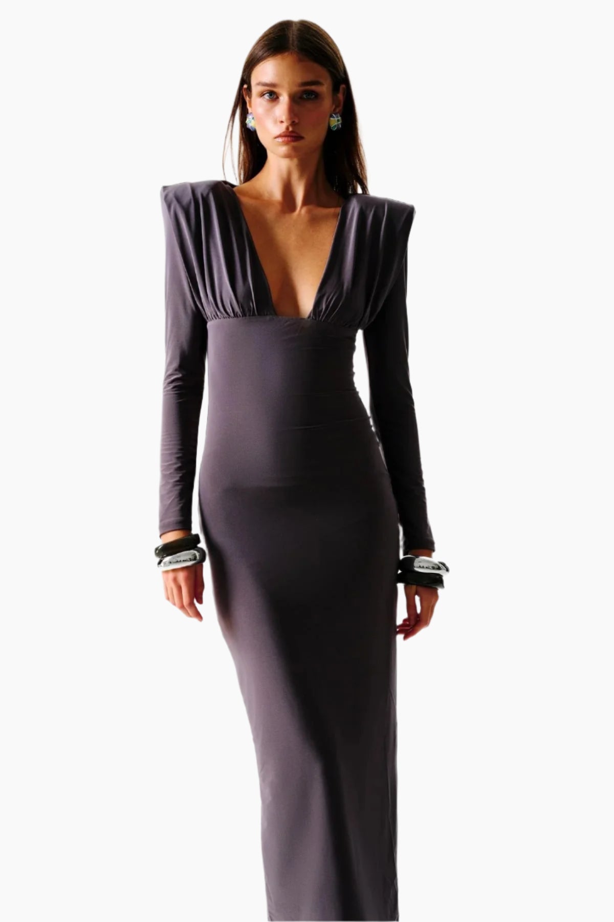 Woman wearing a long, dark purple evening gown with a deep neckline