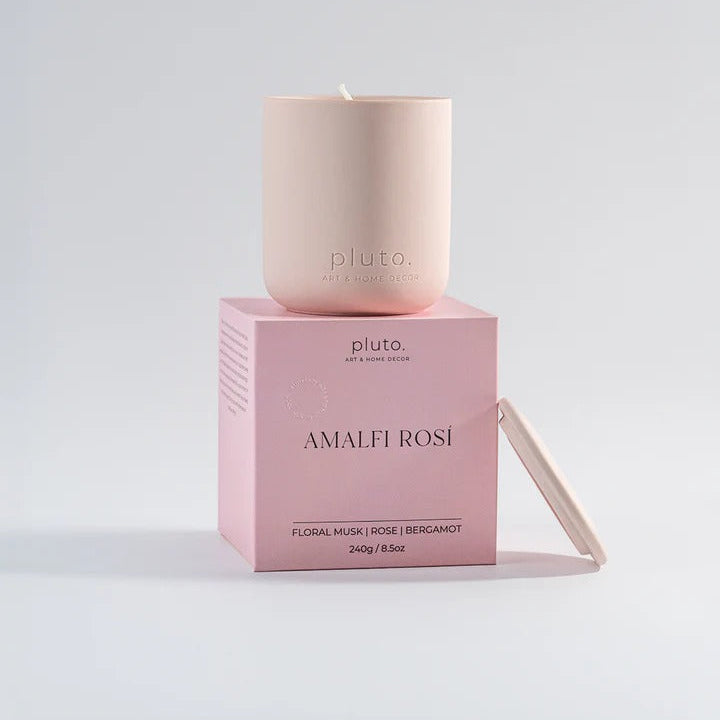 Pink candle on a pink box with 'Pluto' branding on a light gray background