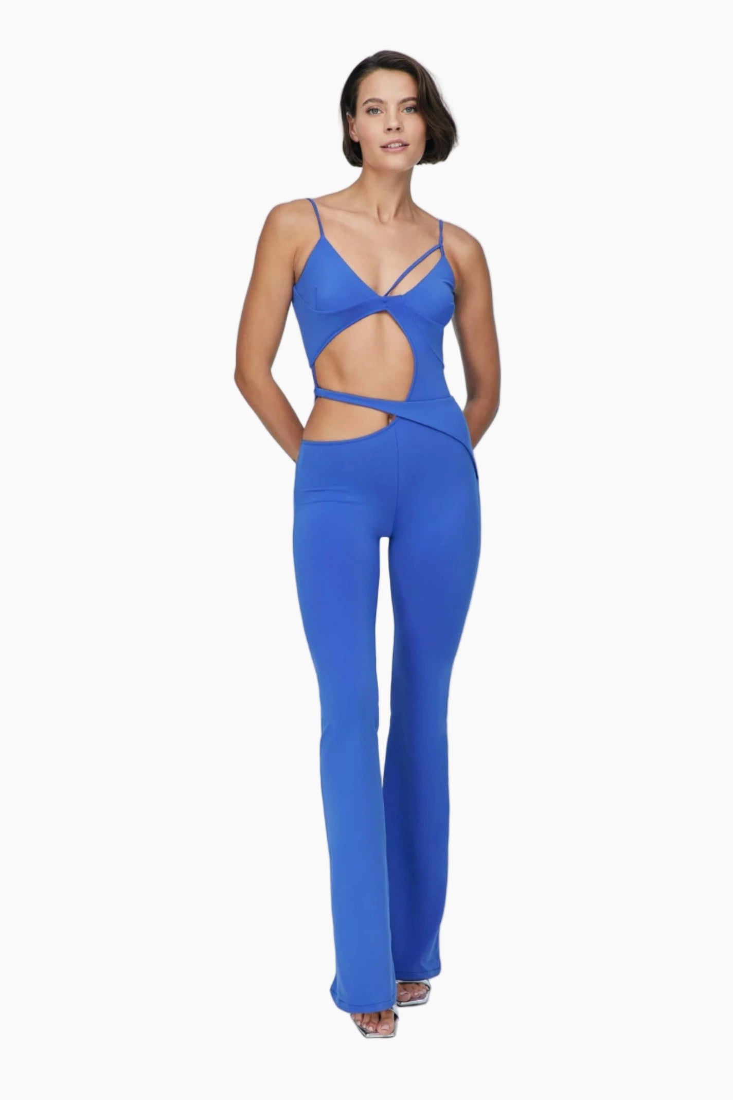 Woman wearing a blue jumpsuit Featuring asymmetric cut out details and chic straps.