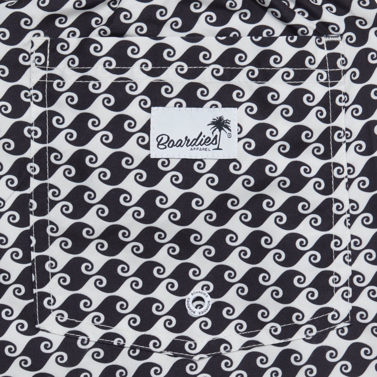 Black and white wavy patterned boardshorts with a visible brand label.