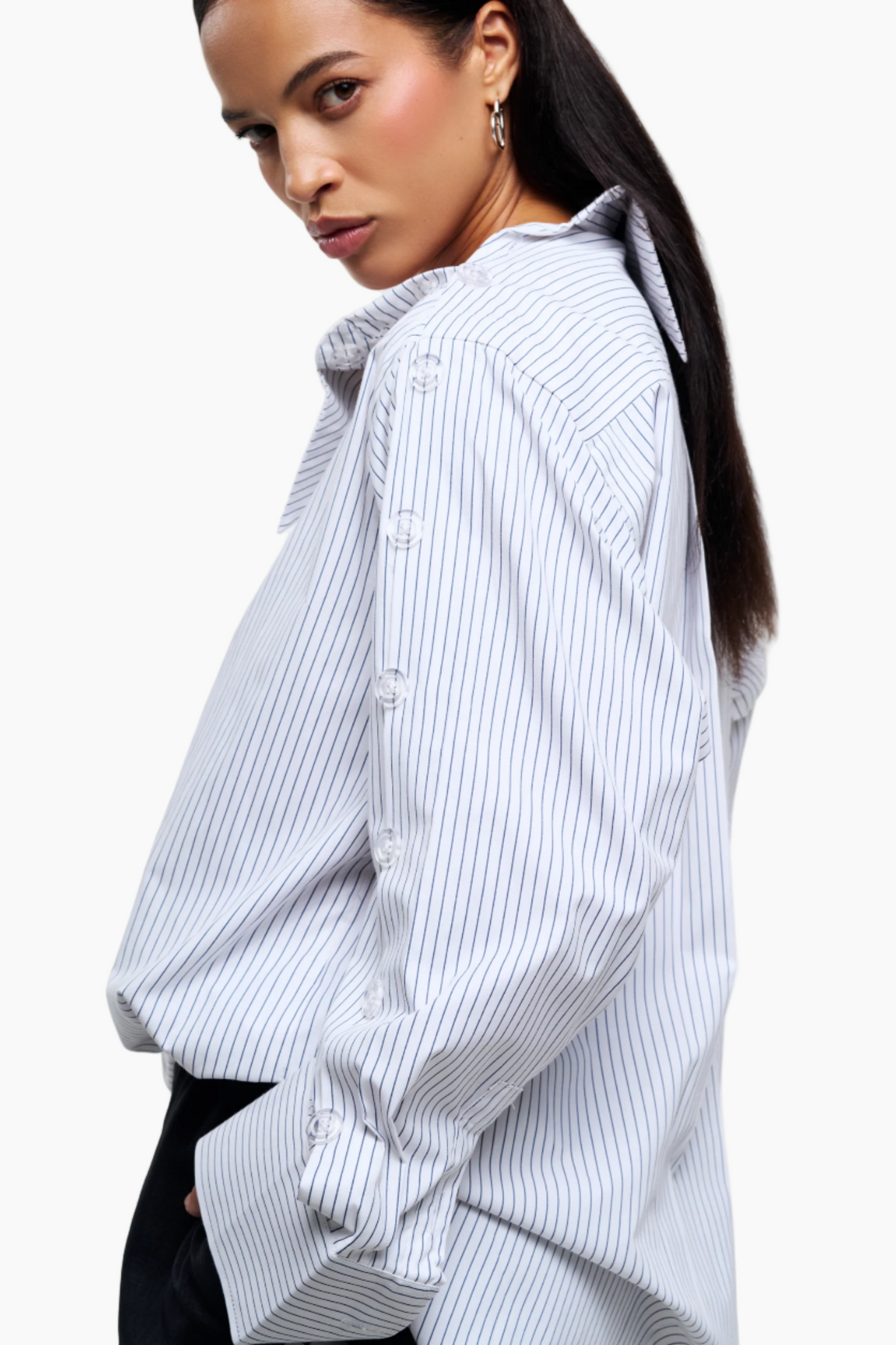 Woman wearing a light blue and white striped shirt on a white background