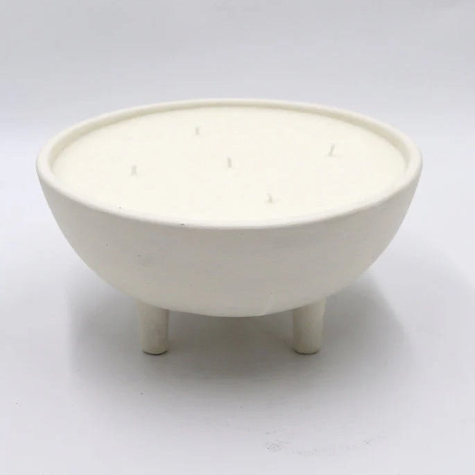 White ceramic bowl with three legs on a light gray background
