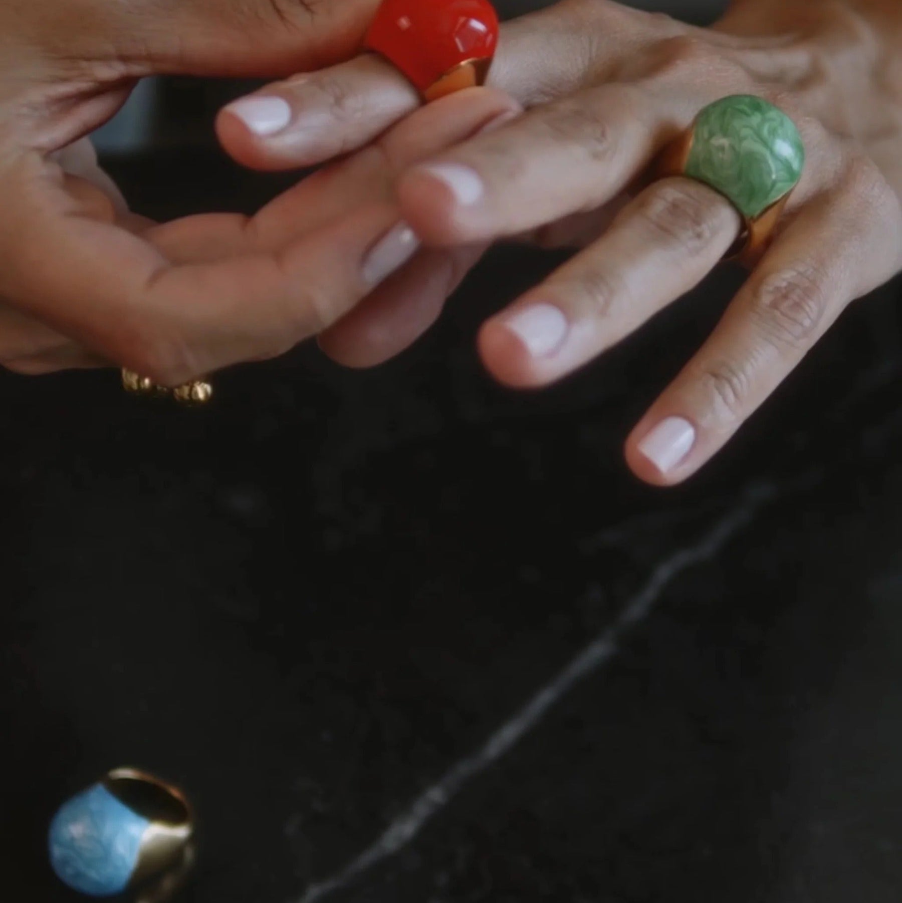 Close-up of hands with rings on a dark background