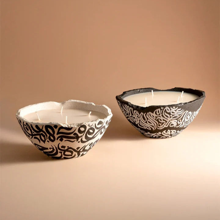 Two ceramic bowls with black and white patterns on a beige background
