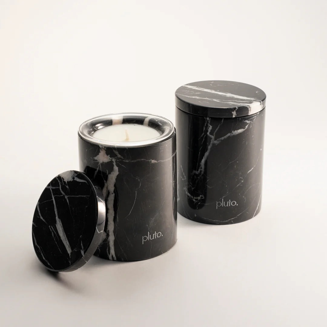 Two black marble-patterned candle containers with a lit candle inside