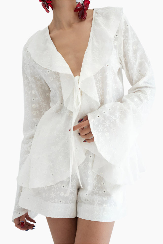 model wearing a white lace shirt with a matching white shorts