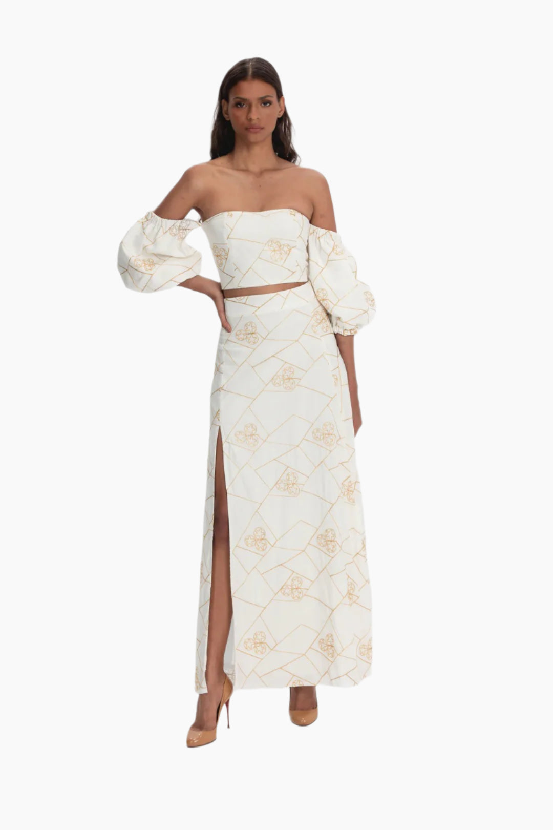 Woman wearing a white floral set, embroidered and puffed sleeve crop top and a skirt with a split