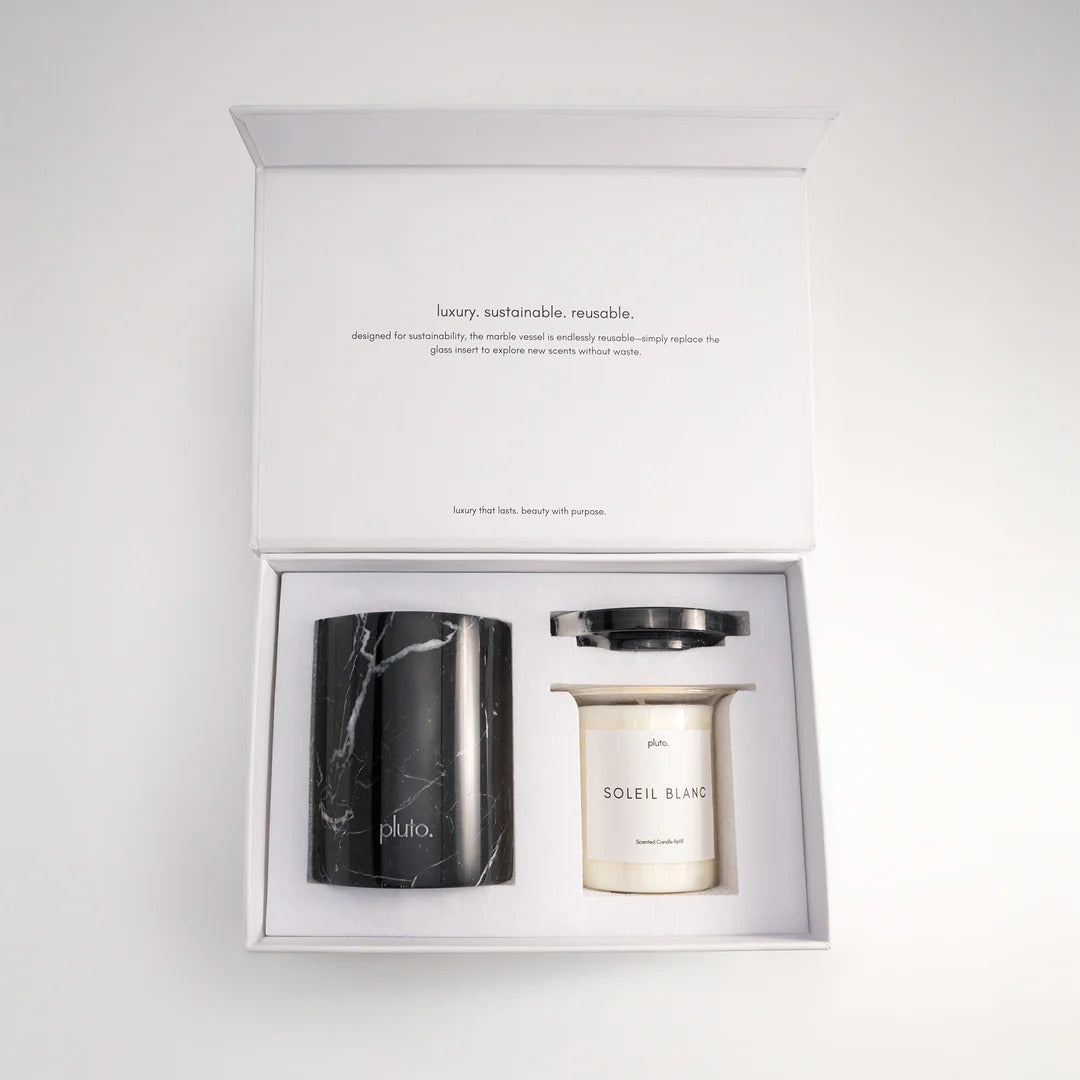 Two candles, one black and one white, in a box with branding text