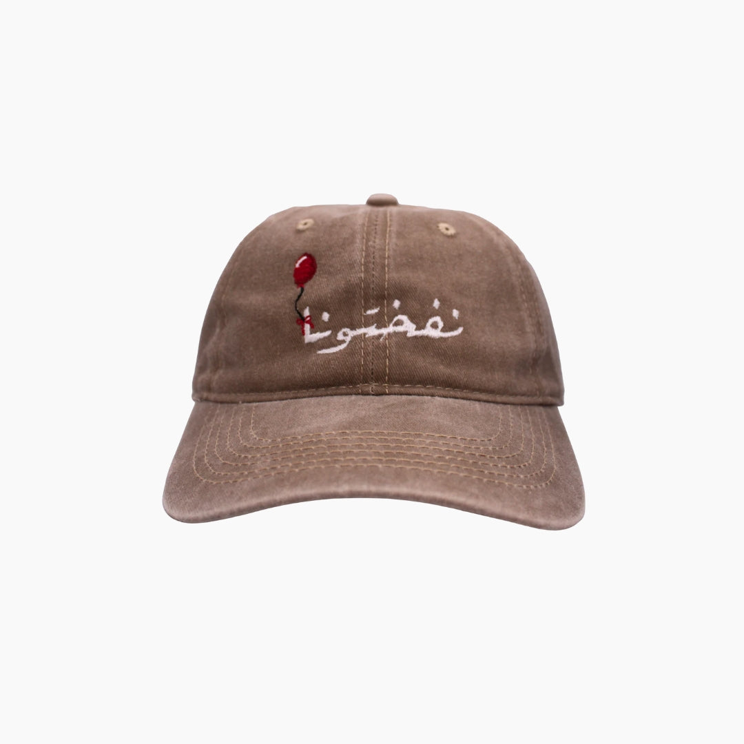 Brown cap with red balloon and white text
