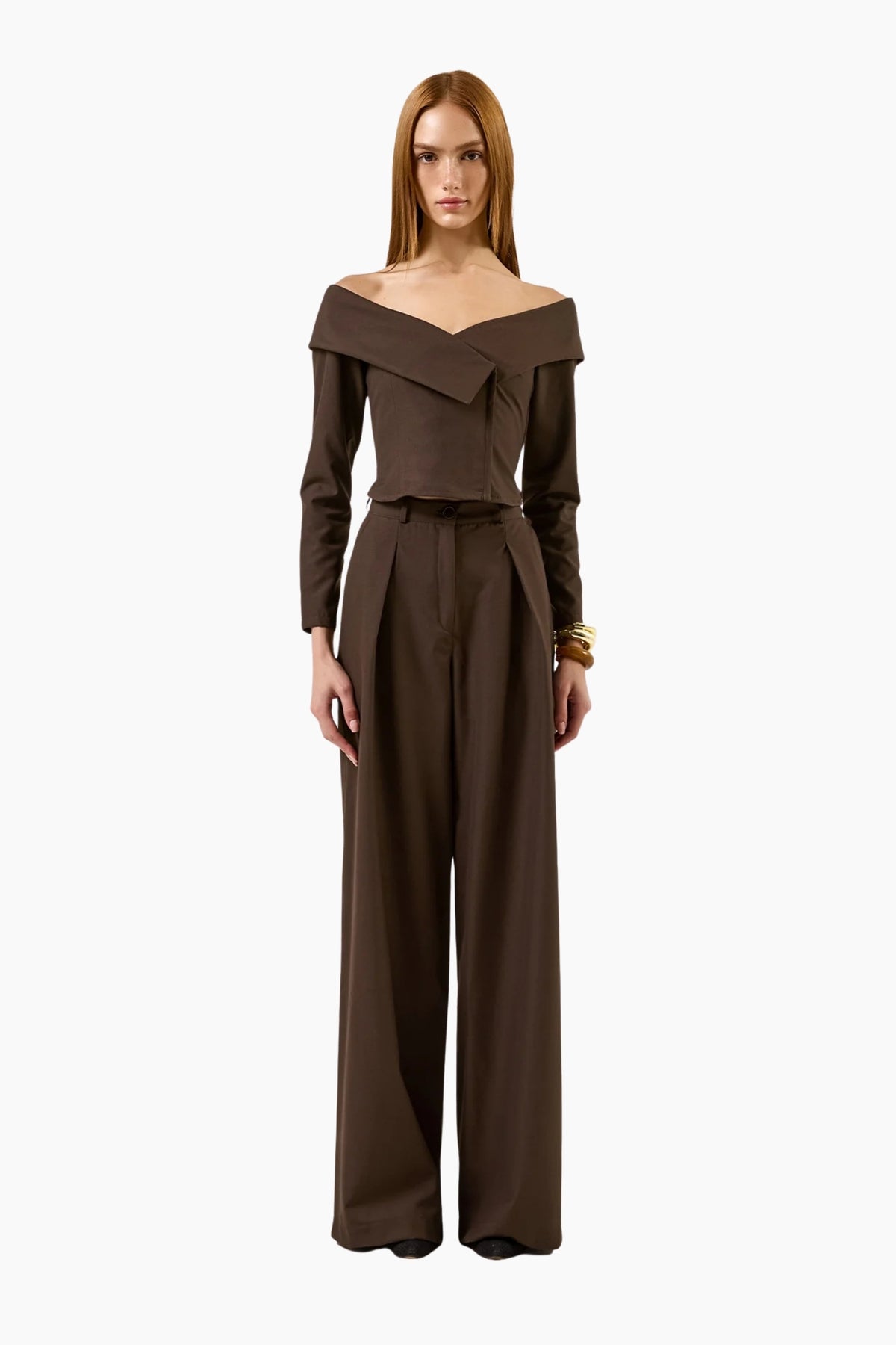 model wearing an Off-shoulder double-breasted long-sleeves top with brown pants.