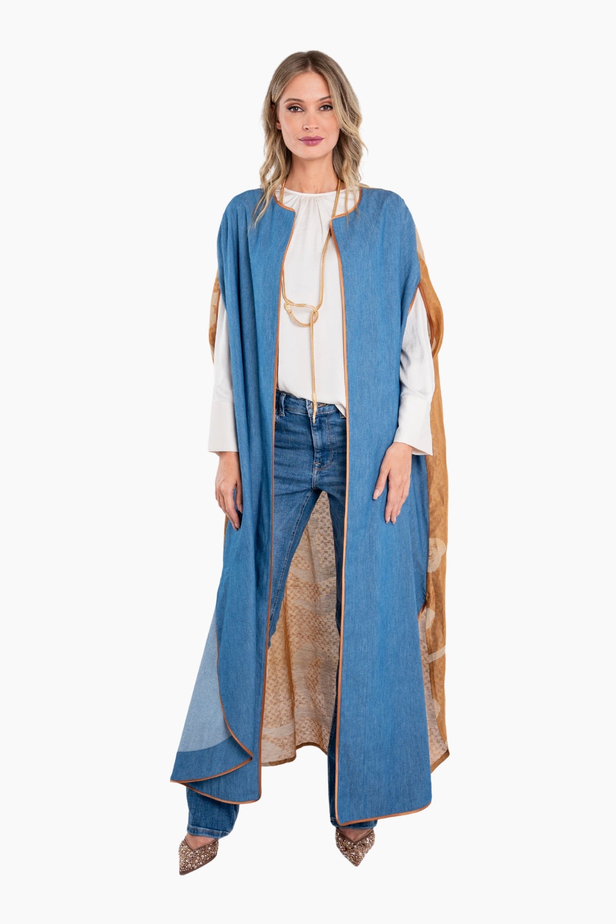 Woman wearing a long blue coat over a white blouse and jeans on a white background