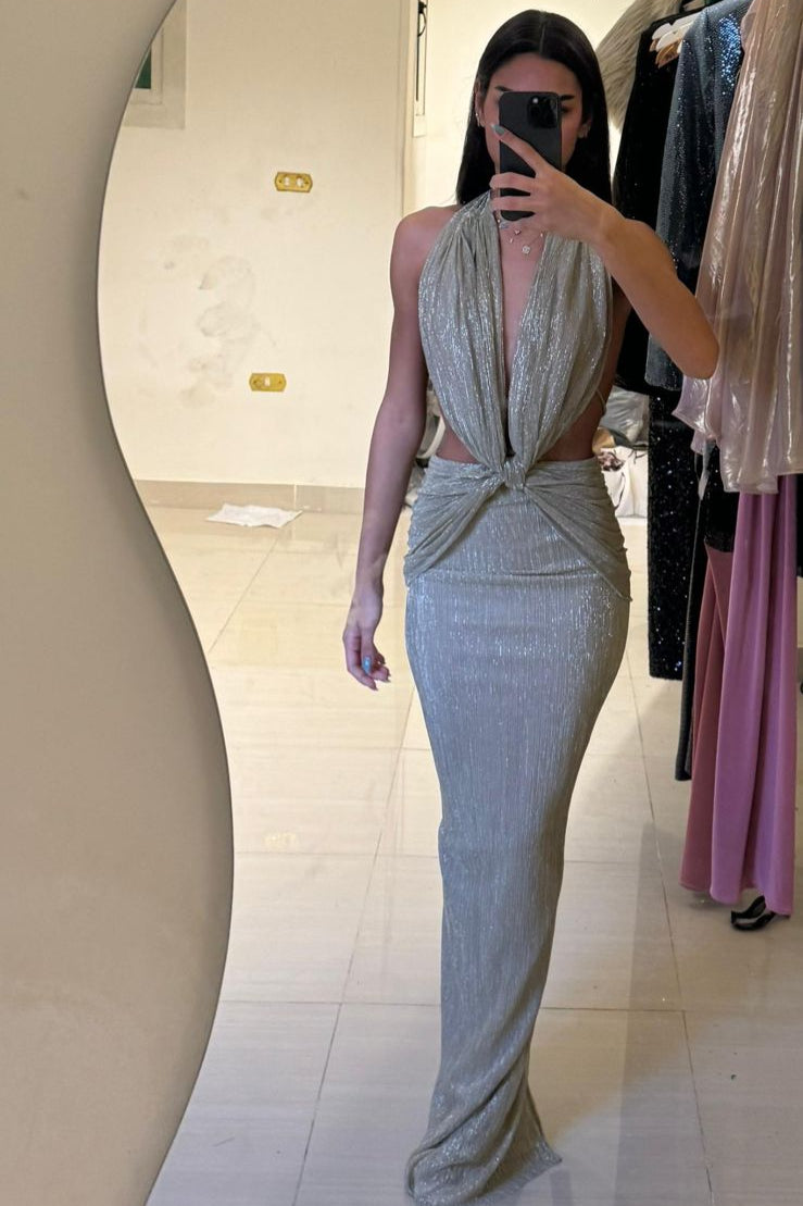 Woman wearing a sparkly silver dress in a fitting room.