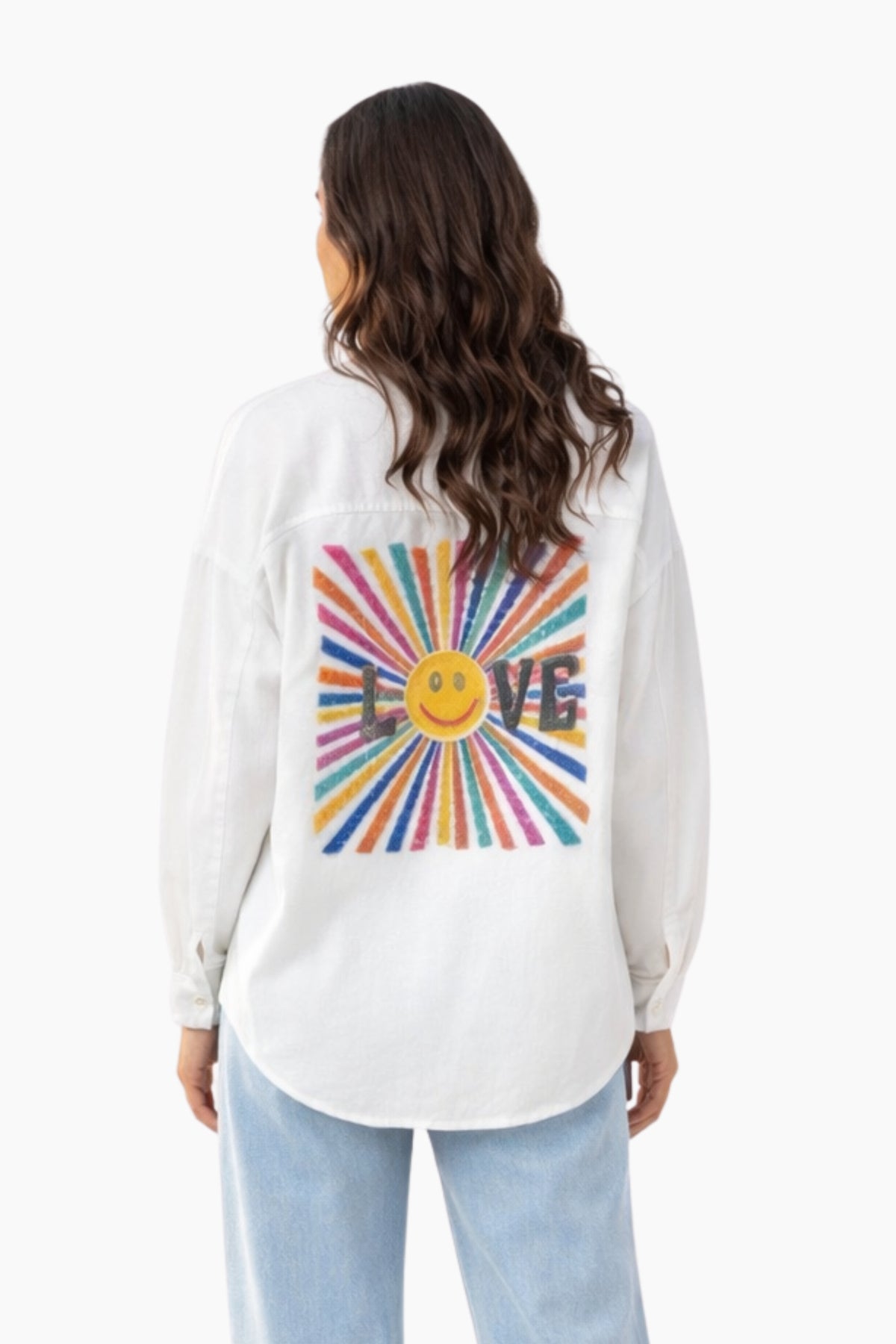 Woman wearing a white long-sleeve shirt with a colorful 'LOVE' design on the back.