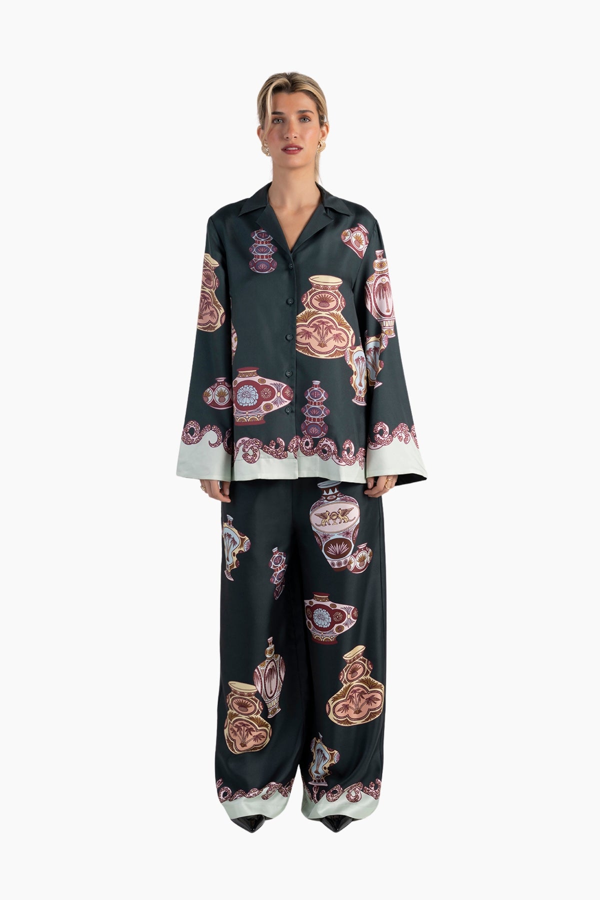 Woman wearing a black pajama set with a colorful abstract pattern on a white background