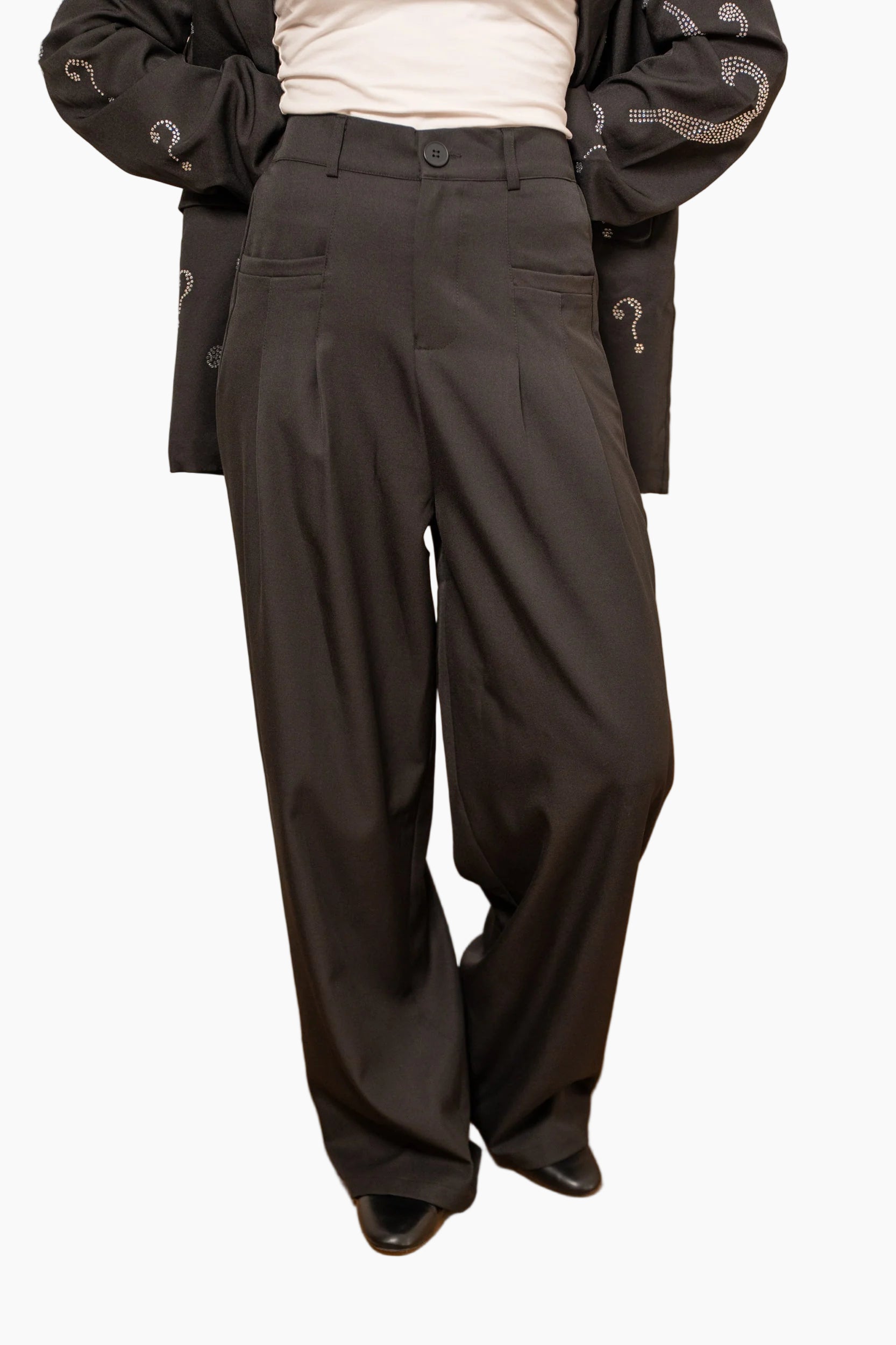 Person wearing Flowing pants with a wide and elegant cut,i brown high-waisted pants .