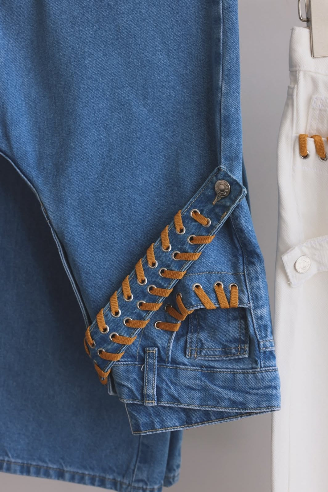 Blue denim jacket with decorative cut-out details on a gray background