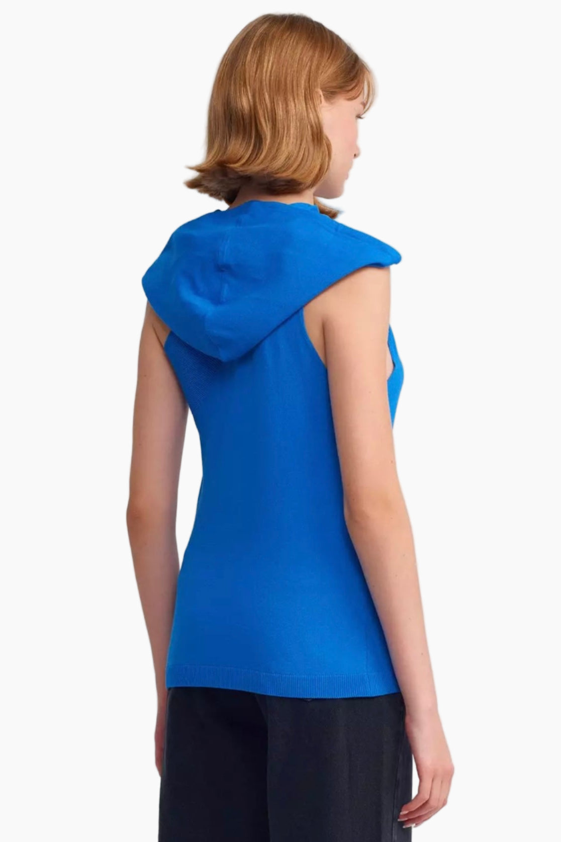 Woman wearing a blue sleeveless top with a hood on a white background